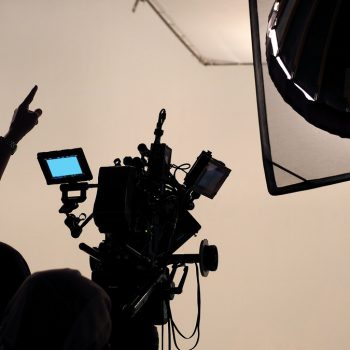 Behind the scene of tv movie video film shooting production crew team and camera lighting set in the big studio.