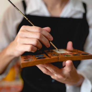 creative artist working on colours art to drawing picture with brush paint in hobby, watercolor paintbrush tool craft workshop with canvas in studio, palette easel and artwork design background